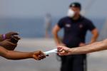 Migranter kommer til Europa via flere veje. Her giver politiet på den italienske ø Lampedusa et mundbind til en migrant, der er kommet til øen og som skal videre til fastlandet. Den danske ambition om et modtagecenter i et afrikansk land lever endnu. Udenrigsminister Jeppe Kofod besøger tirsdag og onsdag Marokko, der bringes i spil til at huse modtagecenter. Foto: Guglielmo Mangiapane/Ritzau Scanpix