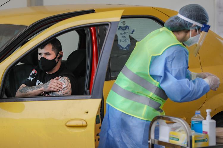 En mand venter i sin bil efter at have modtaget et skud vaccine mod covid-19 ved det første drive-through-vaccinationscenter i Rumæniens hovedstad Bukarest.  Foto: Vadim Ghirda/Ritzau Scanpix