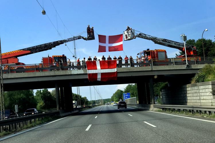 På opfindsom vis bød brandvæsenet landsholdet velkommen tilbage til Danmark efter sejren i EM-kvartfinalen - mange danskere hyldede spillerbussen fro motorvejsbroer. Foto: Jacob Ehrbahn/POLFOTO