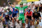 Mark Cavendish suser i mål som vinder for tredje gang i årets Tour de France, og bag ham jubler holdkammeraten Michael Mørkøv på sjettepladsen over triumfen.
 Foto: Stephane Mahe/Ritzau Scanpix