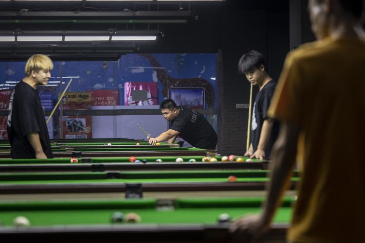 Luo Huazhong (i midten) har skabt en ide om at tage det hele mere afslappet. Det har gjort ham populær nogle steder, mens han censureres andre steder.  Foto: Qilai Shen/Ritzau Scanpix