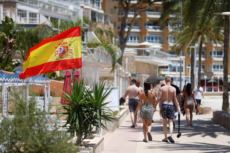 Selv om Mallorca er gået fra grønt til gult i Udenrigsministeriets nye rejsevejledning, kan danske turister stadig nyde livet på Magaluf-stranden.   Foto: Enrique Calvo/Ritzau Scanpix