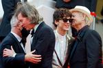 'The French Dispatch'-instruktør Wes Anderson krammer Cannes-direktør Thierry Frémaux (med mundbind), mens skuespilleren Bill Murray måske hvisker i øret på kollegaen Timothee Chalamet, at han og Anderson senere har planlagt at brænde pressen af.  Foto: Eric Gaillard/Ritzau Scanpix