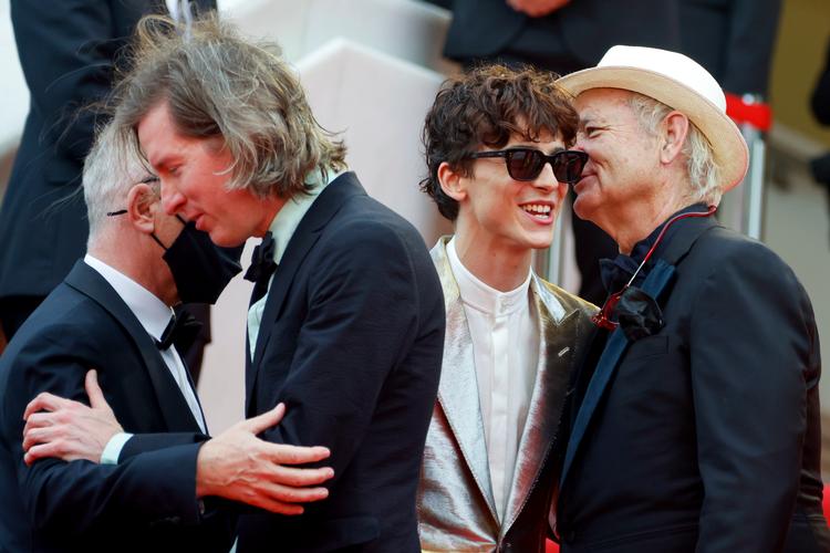 'The French Dispatch'-instruktør Wes Anderson krammer Cannes-direktør Thierry Frémaux (med mundbind), mens skuespilleren Bill Murray måske hvisker i øret på kollegaen Timothee Chalamet, at han og Anderson senere har planlagt at brænde pressen af.  Foto: Eric Gaillard/Ritzau Scanpix