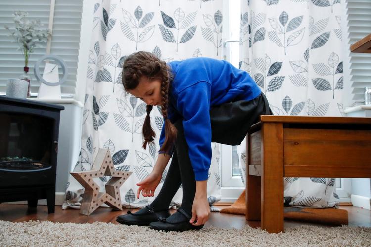 En 8-årig engelsk pige gør sig klar til skoledagen. Foto: Andrew Couldridge (arkiv)/Ritzau Scanpix
