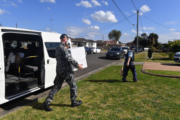Australsk militær afleverer mad til lokale, der skal holde sig indendøre, i  Fairfield, en forstad til Sydney. Foto: Stringer/Ritzau Scanpix