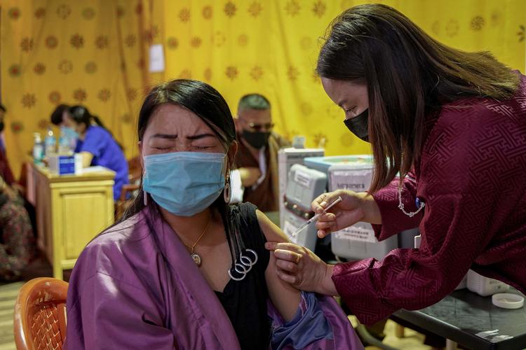 En kvinde får et stik på et vaccinationscenter i Bhutans hovedstad Thimpu. Foto: Upasana Dahal/Ritzau Scanpix