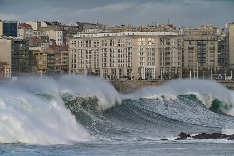 Bølger på over 8 meter hamrer ind over den nordspanske havneby A Coruña under en storm i oktober 2020. Højere havniveau kombineret med flere storme betyder, at mange kystområder er truet. Foto: M. Dylan/Ritzau Scanpix