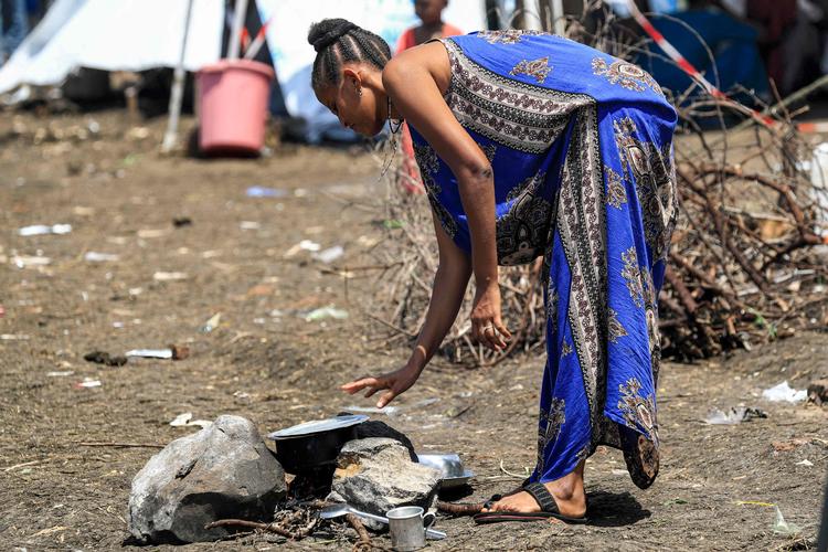 Systematisk vold og seksuelle overgreb mod kvinder og børn har ifølge Amnesty International været udbredt under konflikten i Etiopiens uroplagede region Tigray. På billedet tjekker en etiopisk 
 i en flygtningelejr i Sudan et bål. Foto: Ashraf Shazly/Ritzau Scanpix