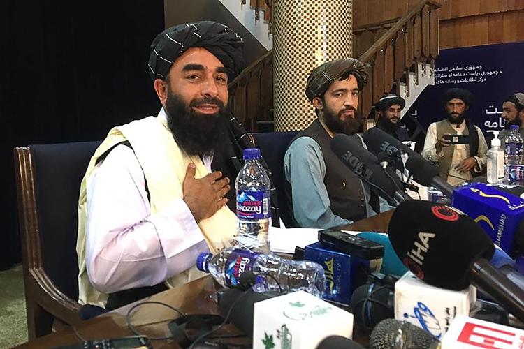 Talebans talsmand Zabihullah Mujahid (tv) under tirsdagens pressekonference i Kabul. Foto: Hoshang Hashimi/Ritzau Scanpix