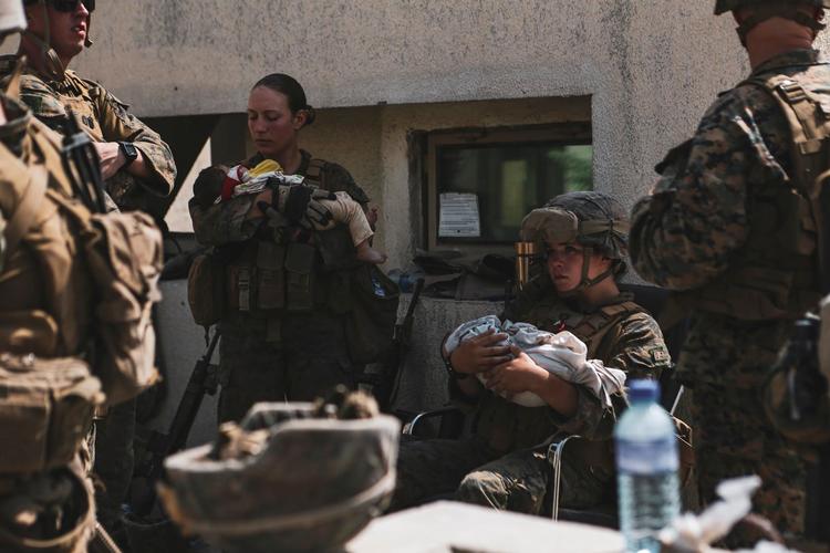  Amerikanske militærfolk holder spædbørn i Hamid Karzai International Airport, Kabul, Afghanistan. Evakueringen efter Taleban-overtagelsen af landet har været præget af kaotiske tilstande og voldsom kamp for at komme ind i lufthavnen, der kontrolleres af amerikansk militær.  Foto: Us Marines/Ritzau Scanpix