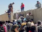 En mand trækker en pige ind på lufthavnsområdet i Kabul. Dansk PEN forsøger også at trække truede forfattere og kulturmedarbejdere ud af Afghanistan. Foto: Stringer/Ritzau Scanpix