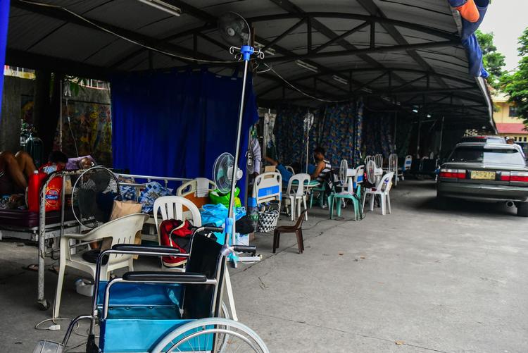 Patienter, der formodes at have covid-19 venter på en parkeringsplads i byen Binan, syd for Filipinernes hovedstad Manila. Området oplever lige nu rekordmange nye smittede. Knap 15 pct. af landets indbyggere er færdigvaccinerede. Foto: Maria Tan/Ritzau Scanpix