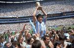 Maradona bæres på skuldrene af holdkammerater, mens han løfter VM-trofæet mod himlen. Han var afgørende for, at Argentina vandt VM i 1986. Foto: Carlo Fumagalli/Ritzau Scanpix