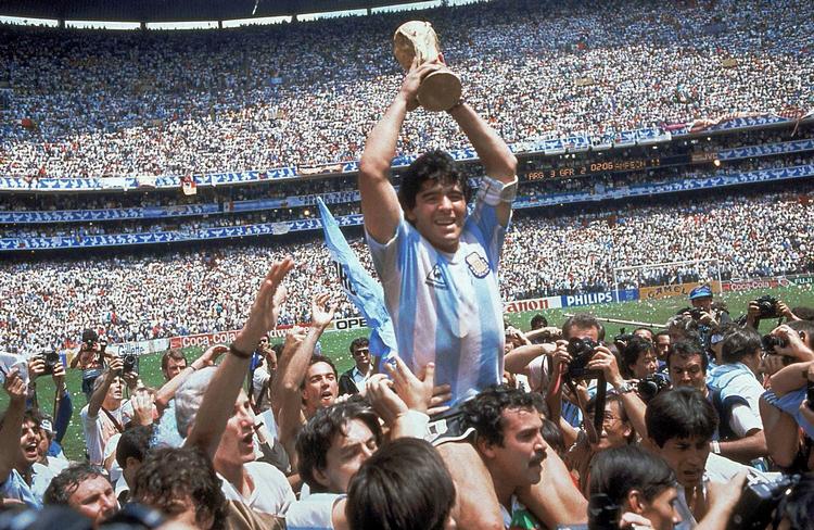 Maradona bæres på skuldrene af holdkammerater, mens han løfter VM-trofæet mod himlen. Han var afgørende for, at Argentina vandt VM i 1986. Foto: Carlo Fumagalli/Ritzau Scanpix