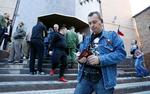 En gruppe mennesker i byen Donetsk står ved et kontor, hvor de skal indlevere deres ansøgning om russisk pas. Manden i forgrunden har kontrafejet af den russiske præsident på sin t-shirt.  Foto: Alexander Ermochenko/Ritzau Scanpix