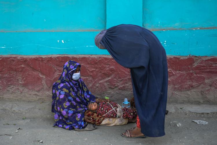 En tildækket kvinde tigger på gaden i Kabul, fotograferet i onsdags. Foto: Bulent Kilic/Ritzau Scanpix