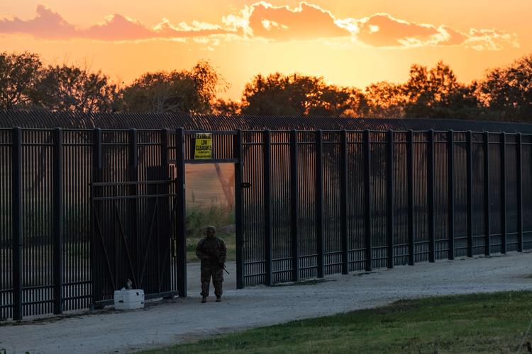 DEL RIO, TX - SEPTEMBER 17: A Texas Army National Guard member guards an opening in the border wall near a makeshift migrant encampment where thousands of migrants have gathered, causing U.S. Customs and Border Protection to close the point of entry between the U.S. and Mexico in response to an influx of immigrants on September 17, 2021 in Del Rio, Texas. According to a statement from the agency, the Del Rio point of entry will be temporarily closed to allocate more resources to the thousands of migrants staying in a makeshift encampment under a nearby bridge, with no specific timeline for reopening. Jordan Vonderhaar/Getty Images/AFP == FOR NEWSPAPERS, INTERNET, TELCOS &amp; TELEVISION USE ONLY == Foto: Jordan Vonderhaar/Ritzau Scanpix