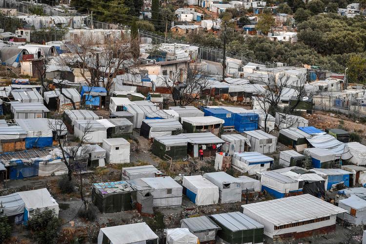 Migranterne i den nyopførte lejr Zervou på den græske ø Samos sad tidligere i denne lejr andetsteds på øen. Den brændte dog, og derfor er der blevet bygget en ny lejr, der bliver overvåget af kameraer og er omkranset af pigtråd og døre, der åbnes med fingeraftryk og elektroniske kort. Foto: Louisa Gouliamaki/Ritzau Scanpix