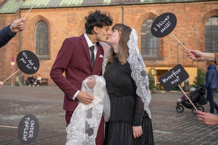 »I bliver skilt!« og »Giv det er par år!« står der på skiltene omkring parret. Men der er ingen, der siger det i programmet. Foto: DR 