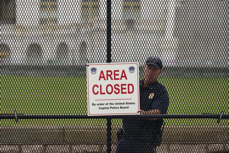 WASHINGTON, DC - SEPTEMBER 17: A member of the U.S. Capitol Police adjusts a sign on security fencing surrounding the U.S. Capitol on September 17, 2021 in Washington, DC. Security in Washington, DC has been increased in preparation for the Justice for J6 Rally, a rally happening this weekend in Washington for support for those who rioted at the U.S. Capitol on January 6 to protest the 2020 presidential election outcome. Drew Angerer/Getty Images/AFP == FOR NEWSPAPERS, INTERNET, TELCOS &amp; TELEVISION USE ONLY == Foto: Drew Angerer/Ritzau Scanpix