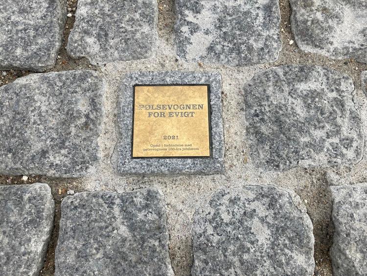 Mindestenen befinder sig tæt på cykelstativerne i Rådhuspladsens nordlige ende og i en akse, der møder rådhusets indgangsparti mod syd. På den tværgående akse ligger den på linjen mellem indgangen til Starbucks og hjørnet af Vesterbrogade. Foto: Annette Nyvang 