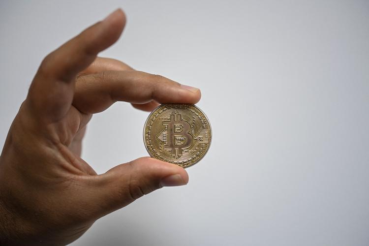Kryptovalutaen bitcoin illustreres typisk med en fysisk guldfarvet mønt, men i virkeligheden er valutaen fuldstændig digital.  Foto: Yuri Cortez/Ritzau Scanpix