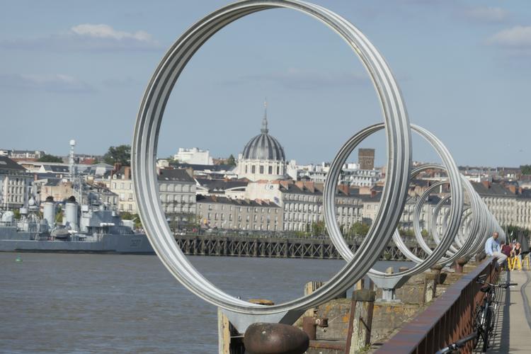 Nantes i den franske region Pays de la Loire er ikke alene grøn i Udenrigsministeriets rejsevejledninger, men naturen holder også fortsat den grønne farve, og på den gamle havnekaj, kan man nyde kunstneren Daniel Burens ringe, som om aftenen lyser i mange forskellige farver. Foto: Poul Husted