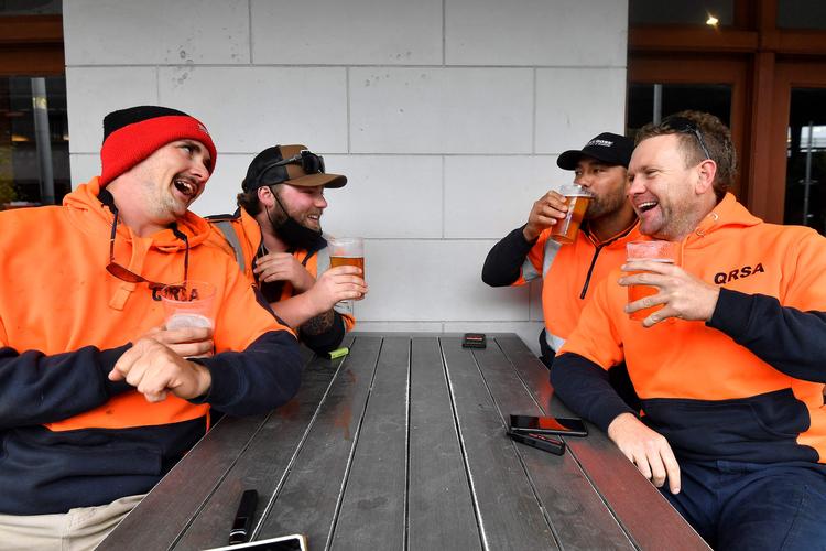 En gruppe byggearbejdere fejrer genåbningen med en øl i Sydney.  Foto: Saeed Khan/Ritzau Scanpix