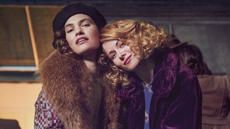 Lily James (tv.) spiller den charmerende og forførende Linda Radlett og Emily Beecham den kloge forsigtige veninde Fanny Logan i den punkede periodedramaserie-version af romanen 'The Pursuit of Love'. Foto: Prime Video/Amazon Studios