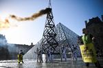     Greenpeace aktivister protesterede 6. oktober foran pyramiden ved Louvre mod Totals fortsatte investeringer i produktion af fossile brændstoffer.  Foto: Anne-christine Poujoulat/Ritzau Scanpix