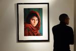 Fotografen Steve McCurry tog billedet af den afghanske pige Sharbat Gula i flygtningelejren Nasir Bagh nær Peshawar i Pakistan i 1984.  På det tidspunkt fik han ikke pigens navn og gav billedet titlen 'Afghan Girl'. I 1985 blev det verdensberømt, da det landede på coveret af National Geographic. Her ses det på en auktion hos Christie's i 2012. 

 Foto: Stan Honda/Ritzau Scanpix
