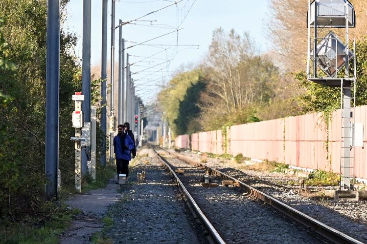     Migranter går langs banelegemet tæt på Calais for at undgå politiet. Sidste uge blev en gruppe påkørt af et tog, en mistede livet, og flere blev kvæstet. Foto: Denis Charlet/Ritzau Scanpix