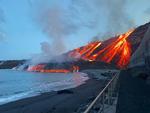 Lava fra Cumbre Vieja vulkanen løber ned ad bjergsiden og ud i Atlanterhavet ved Los Guirres stranden på den kanariske ø La Palma. Foto: Spanish Transport Ministry/Ritzau Scanpix