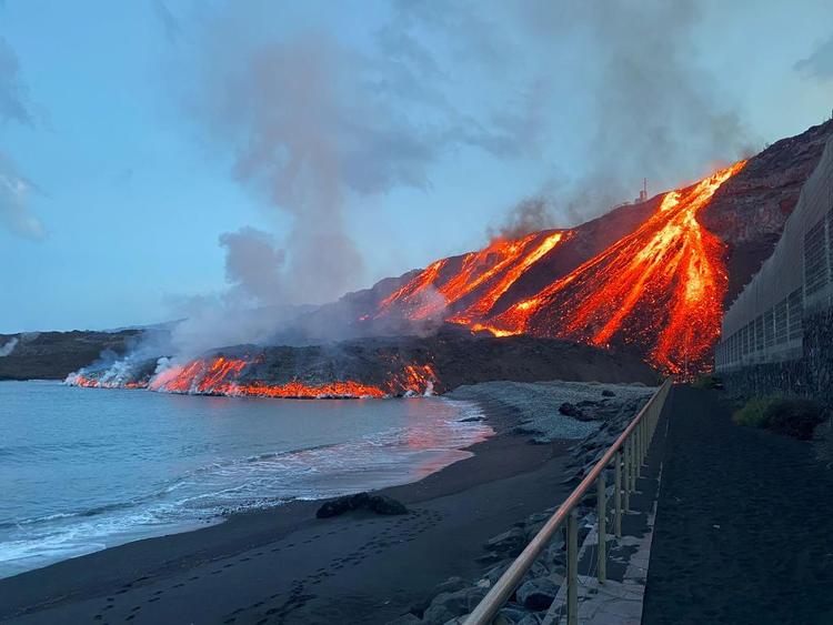 Lava fra Cumbre Vieja vulkanen løber ned ad bjergsiden og ud i Atlanterhavet ved Los Guirres stranden på den kanariske ø La Palma. Foto: Spanish Transport Ministry/Ritzau Scanpix