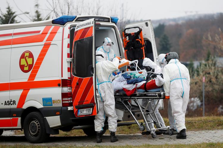 Tjekkiske sundhedsarbejdere er i gang med at overføre en coronapatient til et andet hospital tidligere i dag.  Foto: David W Cerny/Ritzau Scanpix