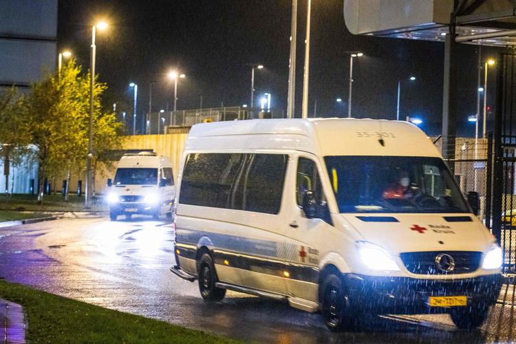 En Røde Kors-varebil transporterer her en række flypassagerer fra Sydafrika væk fra lufthavnen i Amsterdam i Holland, efter at de er blevet testet positive for covid-19. Frygten er, at de bærer den nye variant B.1.1.529 i sig. Foto: Laurens Bosch/Ritzau Scanpix