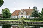 Damgården, i hvis pulterkammer under trappen Lyø Bibliotek befinder sig, ligger ved et af de historiske gadekær på Lyø.  Foto: Kristina Møller