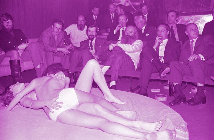 Der var engang, hvor der ikke var noget galt i at bruge en virksomheds firmakonto på at købe erotisk underholdning til forretningsforbindelser, selv om dette indebar, at kvinder måtte stille sig til skue – og måske også rådighed, for det var mændenes verden. Her er det Simon Spies (med stort skæg) på Private Club i 1971. Foto: Jørgen Sperling (farvebehandlet)