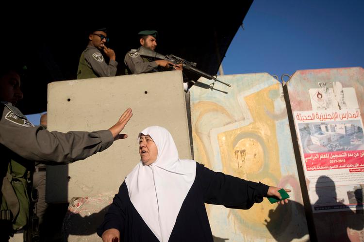  Palæstinensisk kvinde og israelsk soldat ved grænseovergangen mellem Jerusalem og det besatte Vestbredden, hvor Israels regering har udpeget seks ngo'er på Vestbredden som 'terror-organisationer'. Palæstinenserne mener, at det er et forsøg på at afskrække vestlige lande fra at engagere sig i det palæstinensiske samfund.
 Foto: Majdi Mohammed/AP