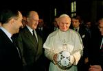 Pave John Paul II med en fodbold mellem hænderne, fotograferet i 1989 før VM-slutrunden i Italien. Manden i midten er Joao Havelange, der er beskrevet som den største idrætsleder, verden nogensinde har set. En mand, der havde mere magt end ... paven. Foto: Giulio Broglio/ASSOCIATED PRESS