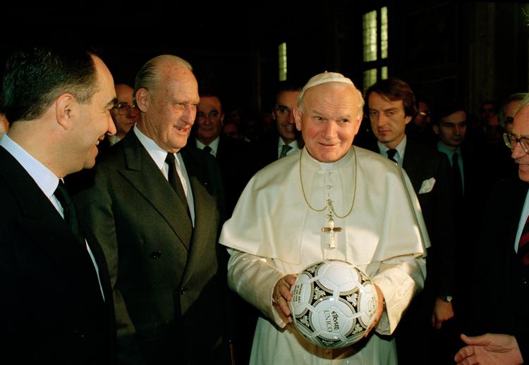 Pave John Paul II med en fodbold mellem hænderne, fotograferet i 1989 før VM-slutrunden i Italien. Manden i midten er Joao Havelange, der er beskrevet som den største idrætsleder, verden nogensinde har set. En mand, der havde mere magt end ... paven. Foto: Giulio Broglio/ASSOCIATED PRESS