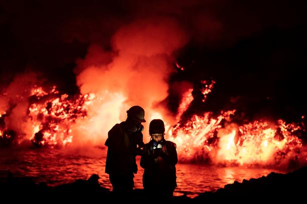 To forskere tager prøver foran flydende lava fra vulkanen på La Palma. Foto: Taner Orribo/Ritzau Scanpix