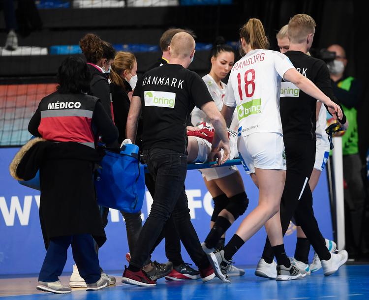   Holdkammeraterne Simone Böhme og Metter Tranborg samt landstræner Jesper Jensen hjalp med at bære Mia Rej ud efter uheldet i åbningskampen. Foto: Lars Poulsen