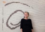 Ane Henriksen foran sit vævede billede 'Skrøbelig'. Materialet er hør, bomuld og opklippet slingredug (skridsikkert underlag til tæpper og måtter) Foto: Ole Akhøj  
