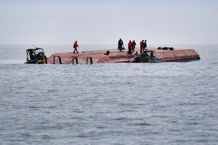 Dykkere arbejder på bunden af det danske fragtskib 'Karin Høj' efter at den er vendt på hovedet efter kollisionen.  Foto: Tt News Agency/Ritzau Scanpix