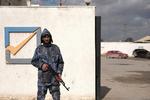 En væbnet vagt foran valgkommissionens bygning i Benghazi i det østlige Libyen.  Fredag skal der være præsidentvalg, men bekymrende lidt er klar. Foto: Esam Omran Al-fetori/Ritzau Scanpix