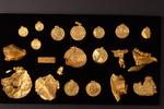 Her kan man se den samlede guldskat fra Vindelev. Skatten omfatter medaljoner, brakteater, et cirkulært hængesmykke med indfattet farvet glas, klinker af guld til reparation og et sværdskedemundblik.   Foto: Foto: Konserveringscenteret i Ve