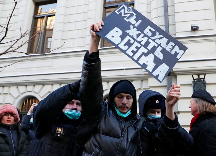Russiske betjente fører en demonstrant væk foran højesteret i Moksva. 'Vi vil leve forevigt' står der på hans plakat.  Foto: Evgenia Novozhenina/Ritzau Scanpix