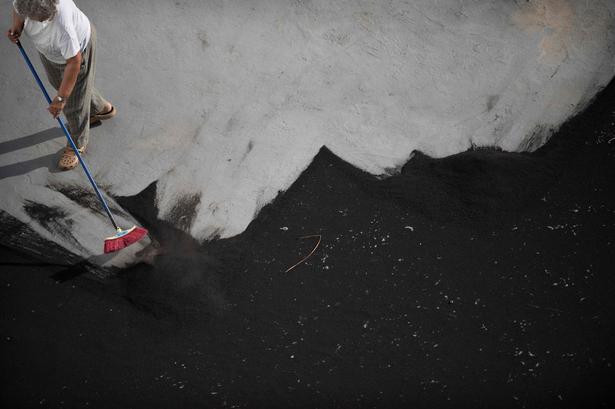 Øens beboere har i løbet af udbrudet knoklet for at holde asken fra vulkanudbruddet væk. En fejekost har været et vigtigt husholdningsredskab de seneste måneder. Foto: Jorge Guerrero/Ritzau Scanpix